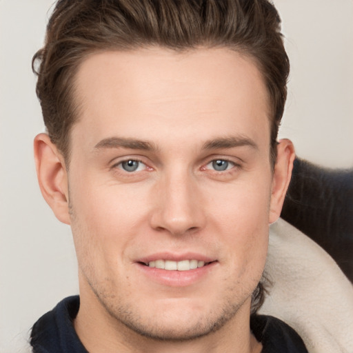 Joyful white young-adult male with short  brown hair and grey eyes