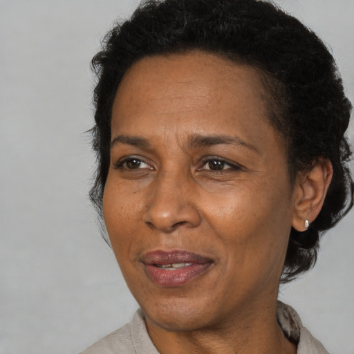 Joyful black adult female with short  brown hair and brown eyes