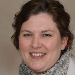 Joyful white adult female with medium  brown hair and blue eyes