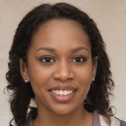 Joyful black young-adult female with long  brown hair and brown eyes