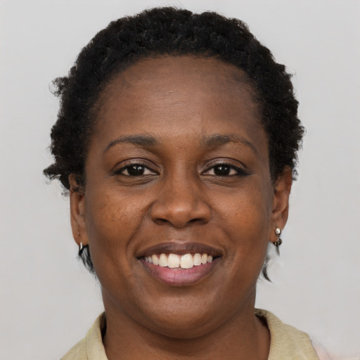 Joyful black young-adult female with short  brown hair and brown eyes