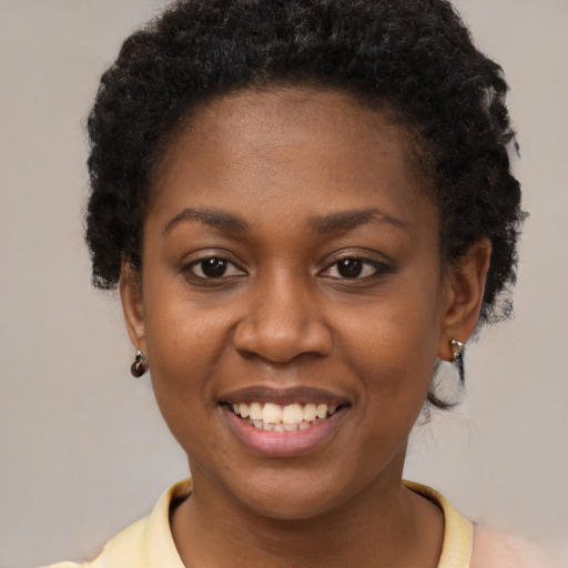 Joyful black young-adult female with short  brown hair and brown eyes
