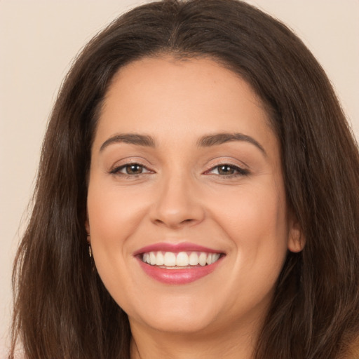 Joyful white young-adult female with long  brown hair and brown eyes