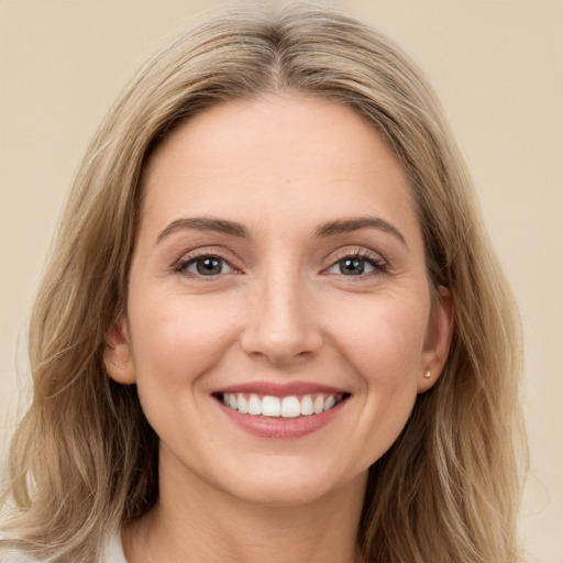 Joyful white young-adult female with long  brown hair and green eyes