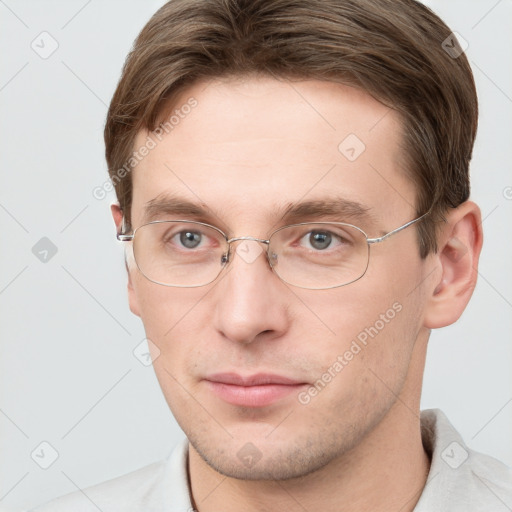 Joyful white young-adult male with short  brown hair and grey eyes