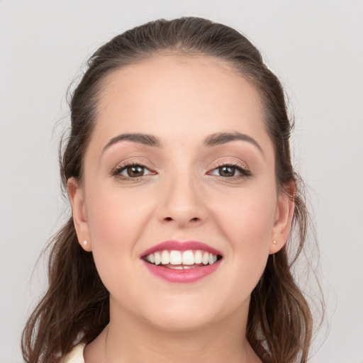 Joyful white young-adult female with long  brown hair and grey eyes