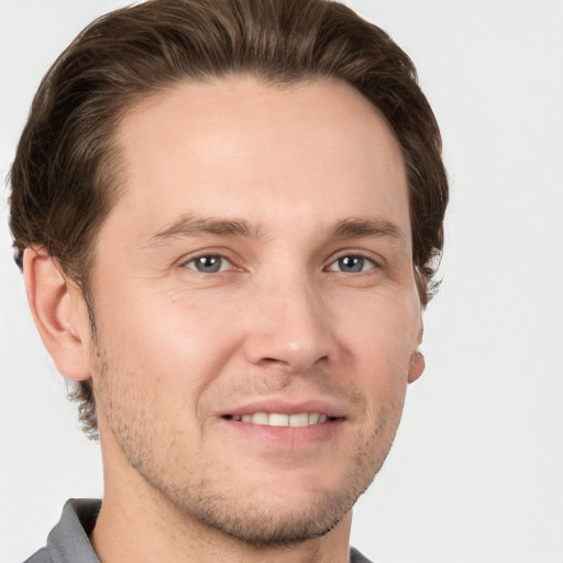 Joyful white young-adult male with short  brown hair and grey eyes