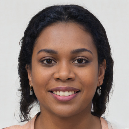Joyful black young-adult female with long  black hair and brown eyes
