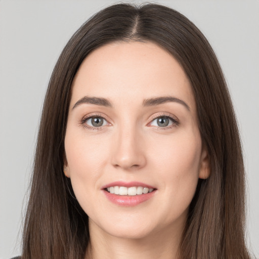 Joyful white young-adult female with long  brown hair and brown eyes