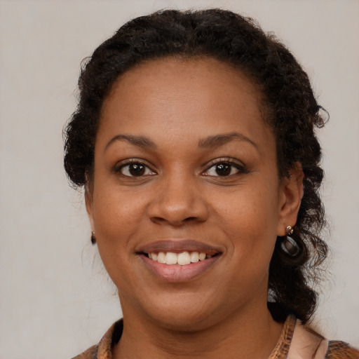 Joyful black young-adult female with medium  brown hair and brown eyes