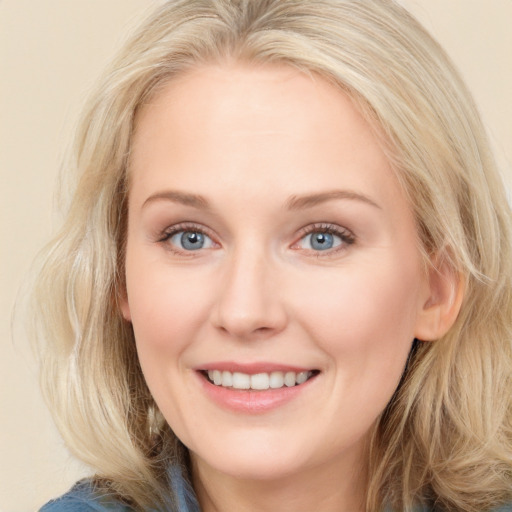 Joyful white young-adult female with medium  brown hair and blue eyes