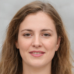 Joyful white young-adult female with long  brown hair and green eyes