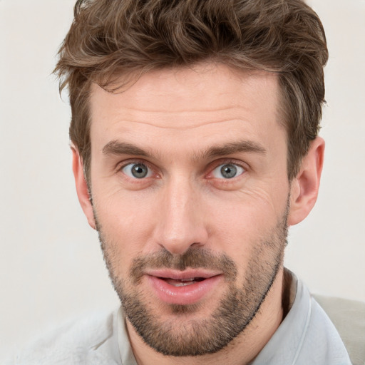 Joyful white young-adult male with short  brown hair and grey eyes