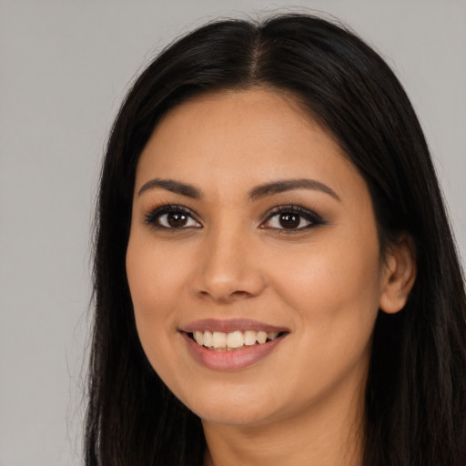 Joyful latino young-adult female with long  black hair and brown eyes