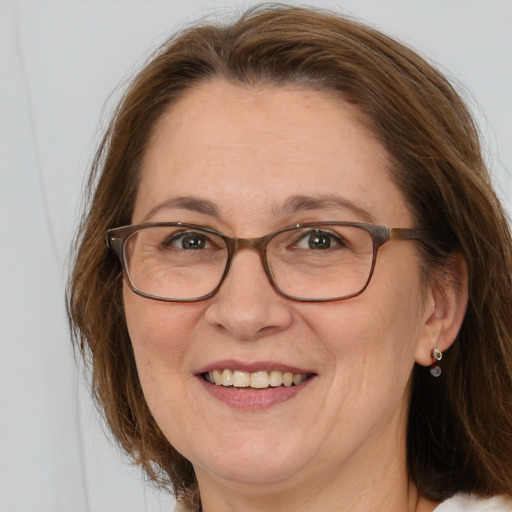 Joyful white adult female with long  brown hair and grey eyes