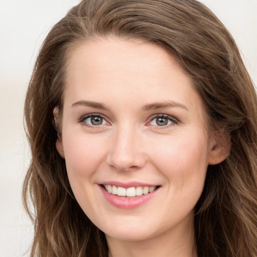 Joyful white young-adult female with long  brown hair and grey eyes