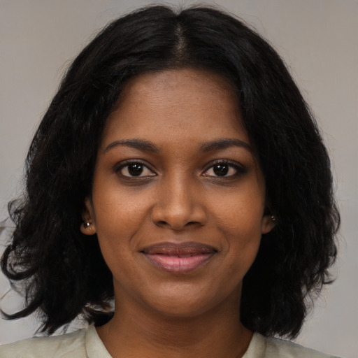 Joyful black young-adult female with medium  black hair and brown eyes