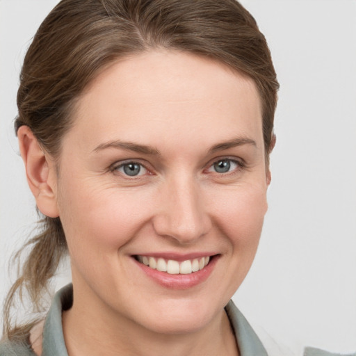 Joyful white young-adult female with medium  brown hair and grey eyes