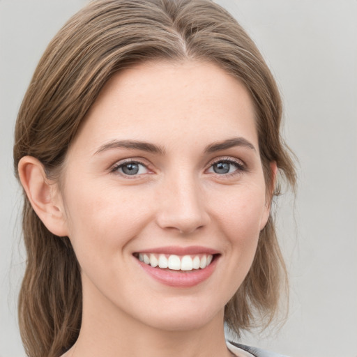 Joyful white young-adult female with medium  brown hair and blue eyes