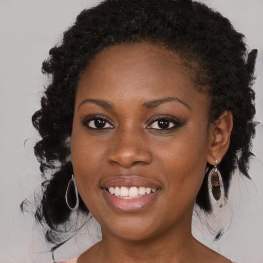 Joyful black young-adult female with long  black hair and brown eyes