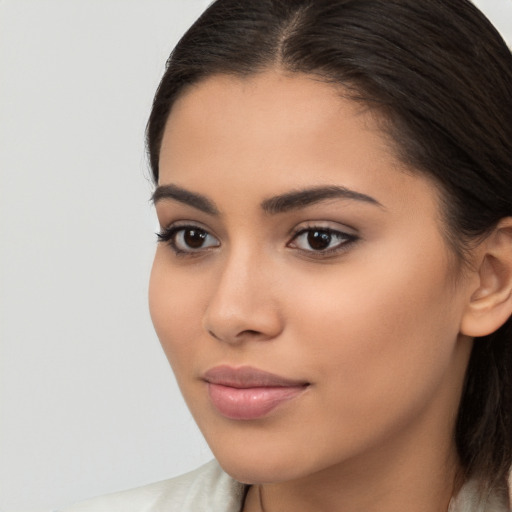 Joyful latino young-adult female with long  brown hair and brown eyes