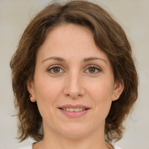 Joyful white adult female with medium  brown hair and green eyes