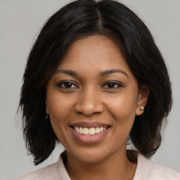 Joyful black young-adult female with medium  brown hair and brown eyes