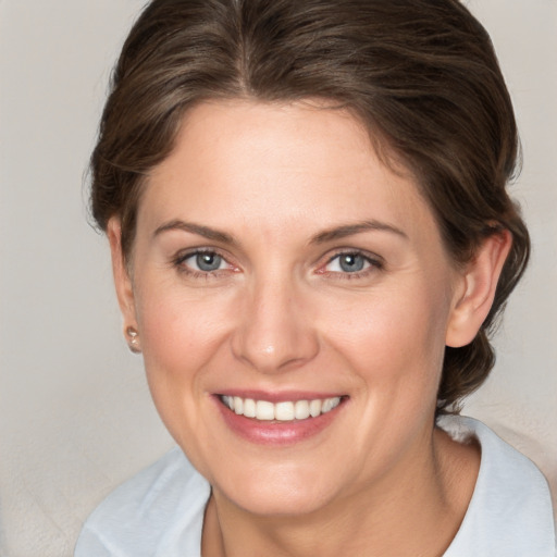 Joyful white adult female with medium  brown hair and grey eyes