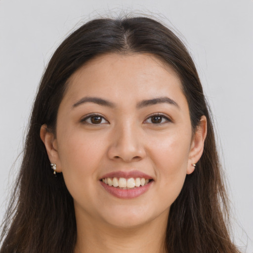 Joyful white young-adult female with long  brown hair and brown eyes