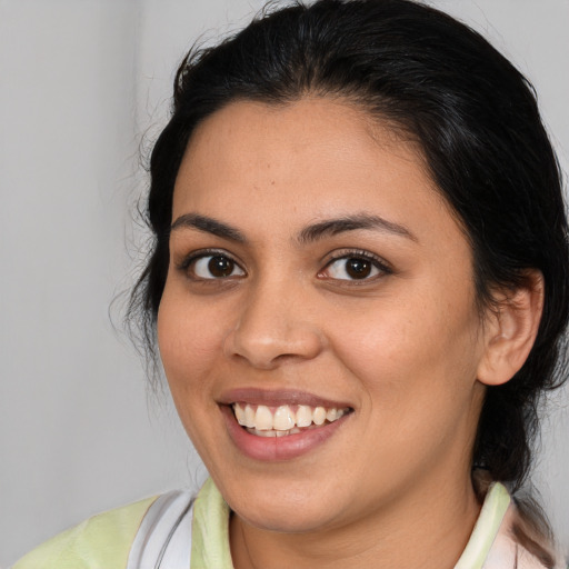 Joyful latino young-adult female with medium  brown hair and brown eyes