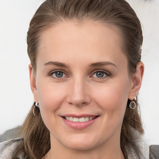 Joyful white young-adult female with medium  brown hair and grey eyes