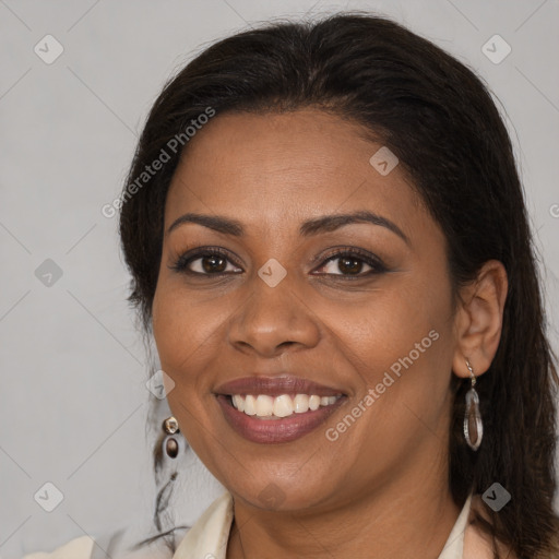 Joyful black young-adult female with long  brown hair and brown eyes