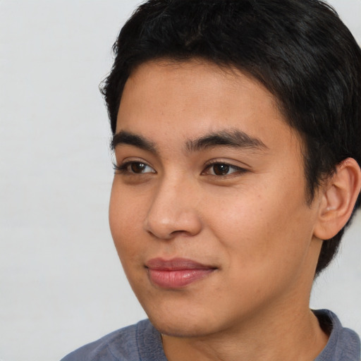Joyful black young-adult male with short  brown hair and brown eyes