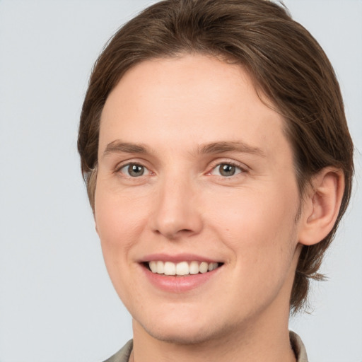 Joyful white young-adult female with short  brown hair and grey eyes