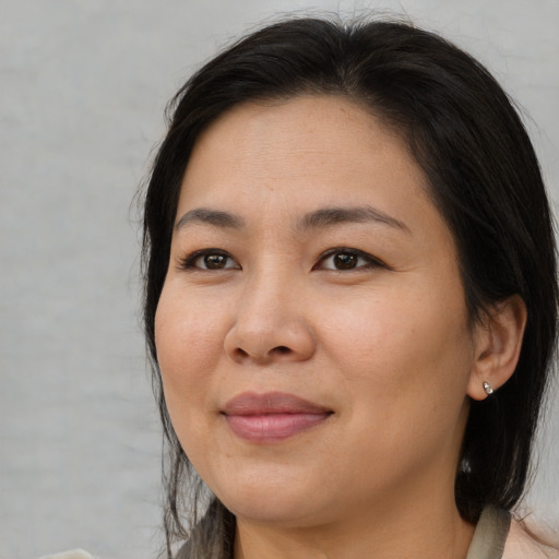 Joyful asian adult female with medium  brown hair and brown eyes