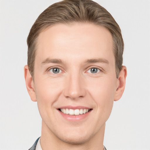 Joyful white young-adult male with short  brown hair and grey eyes