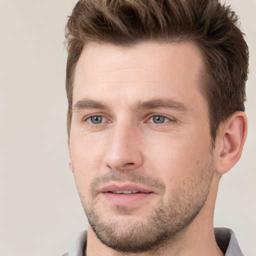 Joyful white young-adult male with short  brown hair and grey eyes