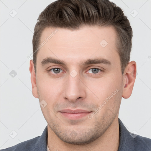 Joyful white young-adult male with short  brown hair and grey eyes