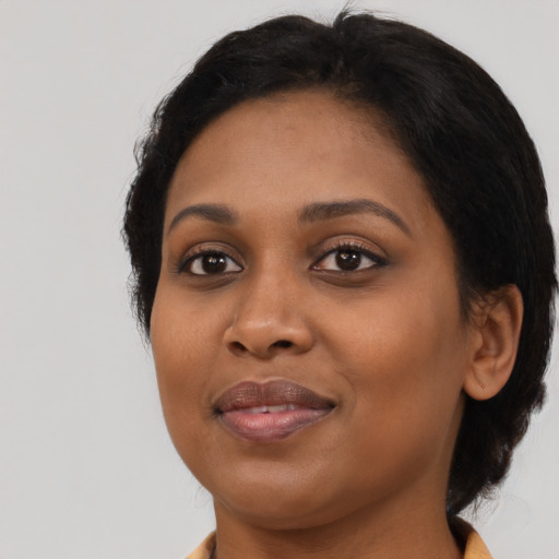 Joyful black young-adult female with medium  black hair and brown eyes