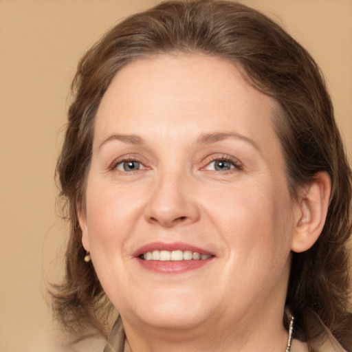 Joyful white adult female with medium  brown hair and grey eyes