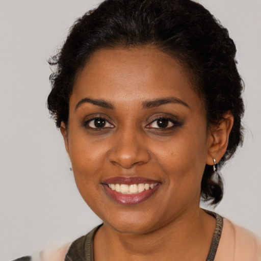 Joyful black young-adult female with short  brown hair and brown eyes