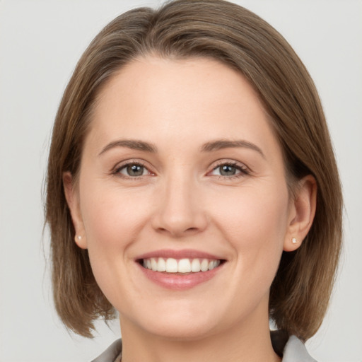 Joyful white young-adult female with medium  brown hair and grey eyes