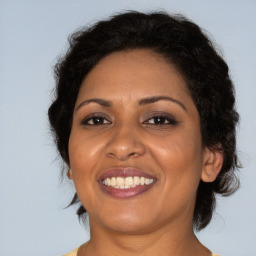 Joyful black adult female with medium  brown hair and brown eyes