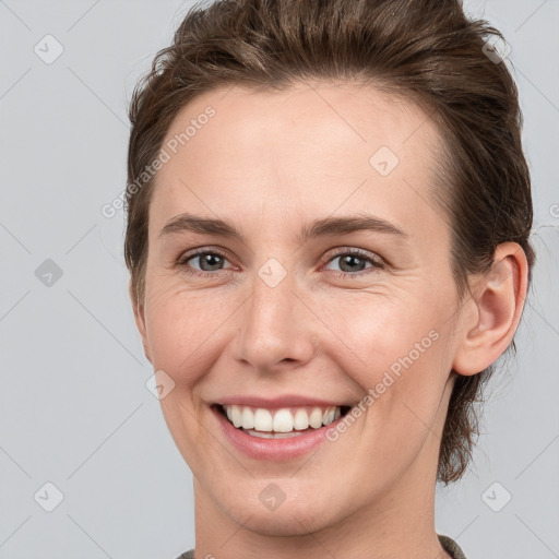 Joyful white young-adult female with medium  brown hair and grey eyes