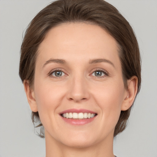 Joyful white young-adult female with medium  brown hair and green eyes