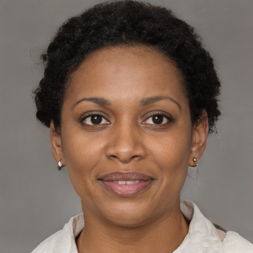 Joyful black adult female with short  brown hair and brown eyes