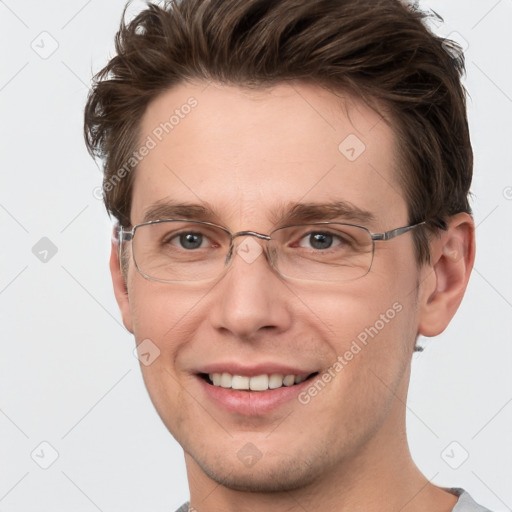 Joyful white adult male with short  brown hair and grey eyes