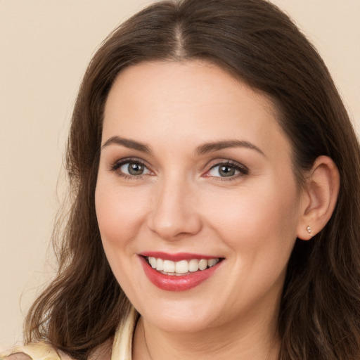 Joyful white young-adult female with long  brown hair and brown eyes