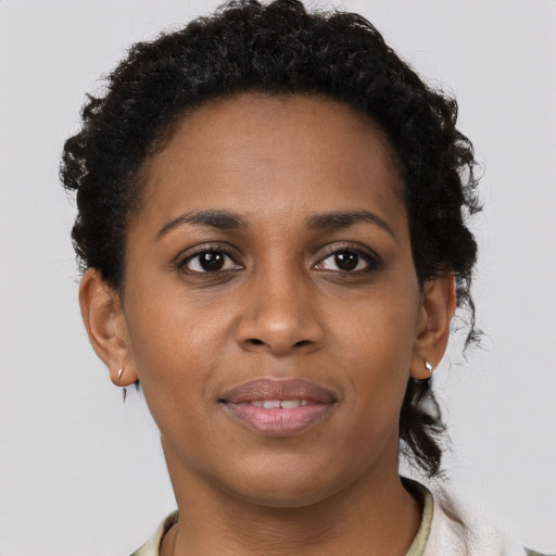 Joyful black young-adult female with short  brown hair and brown eyes