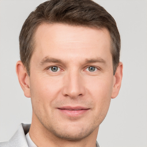 Joyful white adult male with short  brown hair and grey eyes